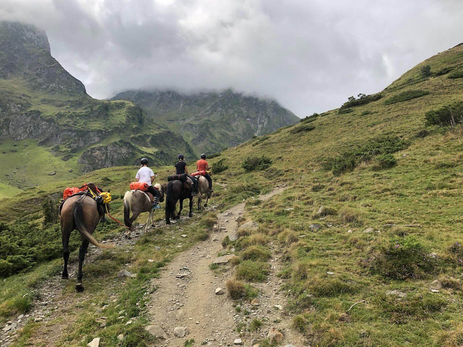 Randonnée à cheval dans les Pyrénées, groupe sous le pic du midi dans les nuages